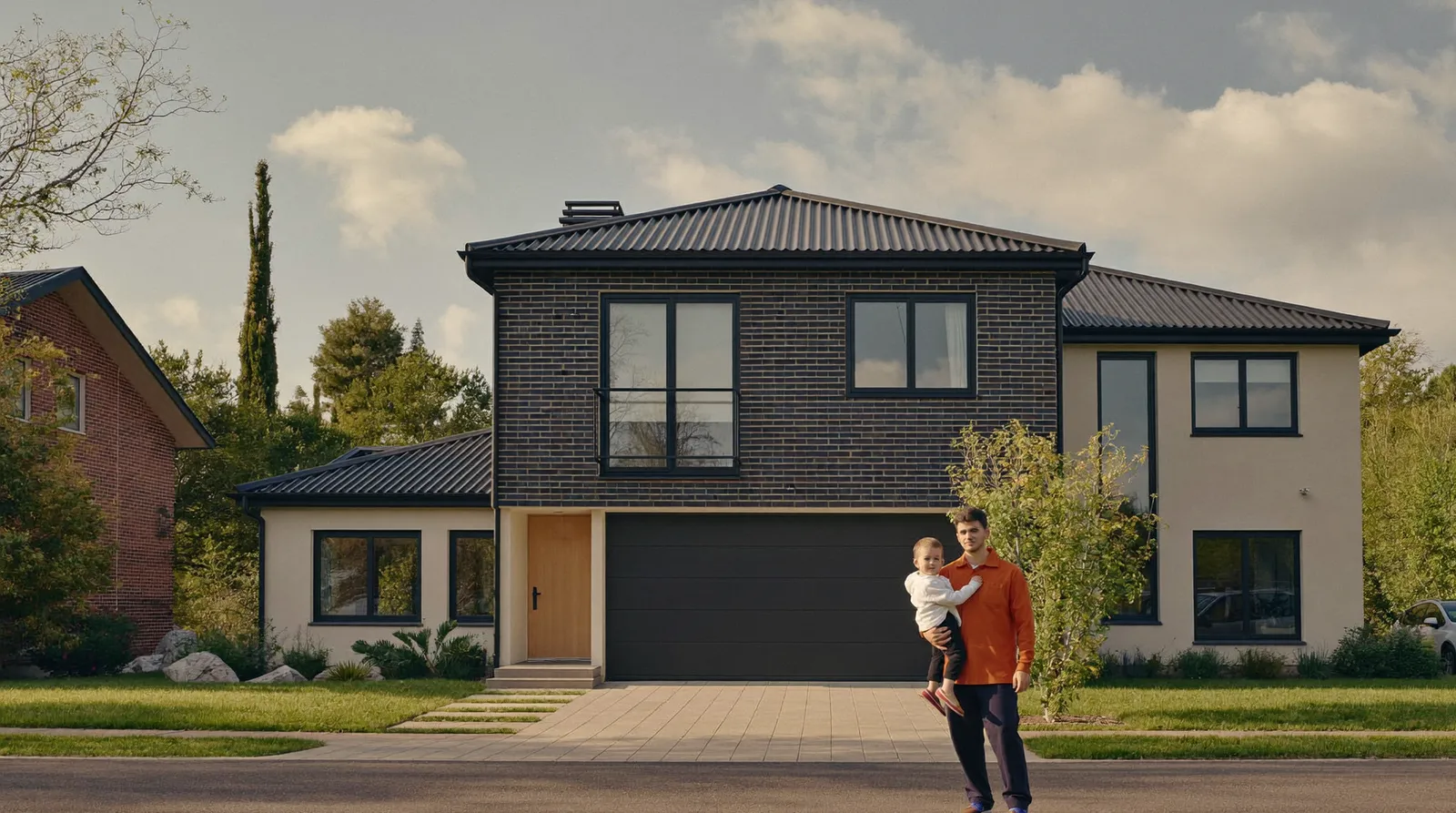 Familie mit Kind vor ihrem Einfamilienhaus